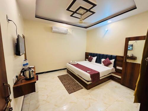 a bedroom with a bed and a tv in it at Shri Sarju Palace in Orchha