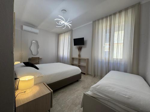 a hotel room with two beds and a television at Paola HOME in Varazze