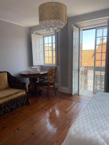 a bedroom with a bed and a table and a couch at Casa Amore in Montemor-o-Velho