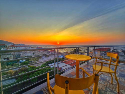 a balcony with a table and chairs and a sunset at Trifonas Loft in Ríva