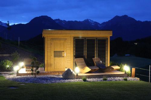 a small shed with two chairs in a yard at night at Landhaus Eiter in Arzl im Pitztal