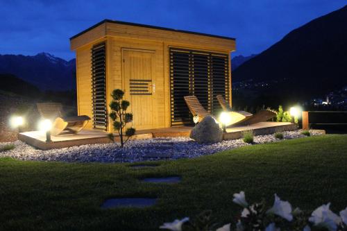 a small building with lights in a yard at night at Landhaus Eiter in Arzl im Pitztal