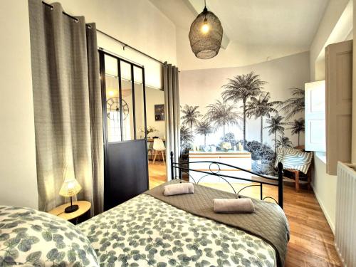 - une chambre avec un lit et des palmiers sur le mur dans l'établissement L'artiste - balcon - clim, à Nîmes