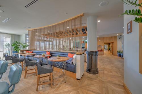 a lobby with tables and chairs and a bar at Hotel Indigo Orange Beach - Gulf Shores by IHG in Gulf Shores
