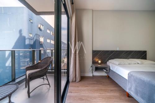 a bedroom with a bed and a balcony with a view at Apart Villa Francione in Bombas