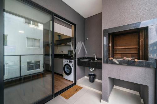a bathroom with a sink and a washing machine at Apart Villa Francione in Bombas