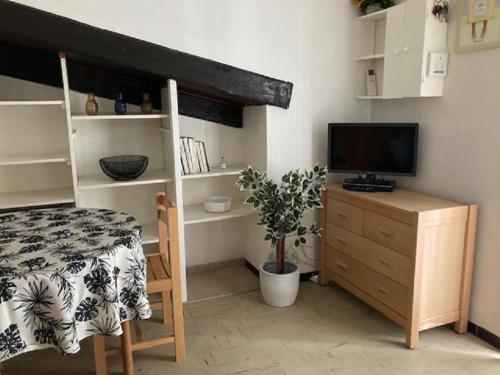 une chambre avec un lit et un bureau avec une télévision dans l'établissement Studio, à Nîmes