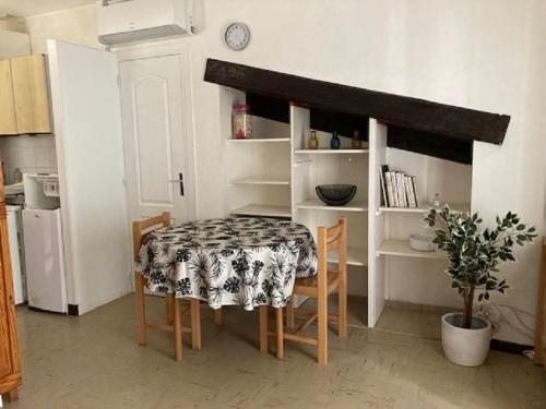 une table et des chaises dans une cuisine avec une table et une table et un réfrigérateur dans l'établissement Studio, à Nîmes