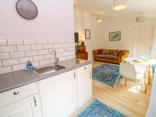 Una cocina con fregadero y una sala de estar. en The Cow Shed, en Truro