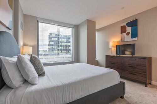 a bedroom with a large bed and a window at Modern Apt in Seaport with Gym in Boston