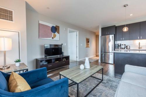 a living room with a blue couch and a table at Modern Apt in Seaport with Gym in Boston