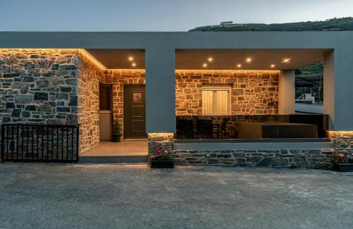 a house with a stone wall and a door at Almyra Seaside Residence 80meters from the beach in Sísai