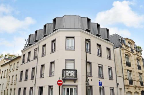 a tall white building with a grey roof at Studio 2P Roland Garros Parc des in Boulogne-Billancourt
