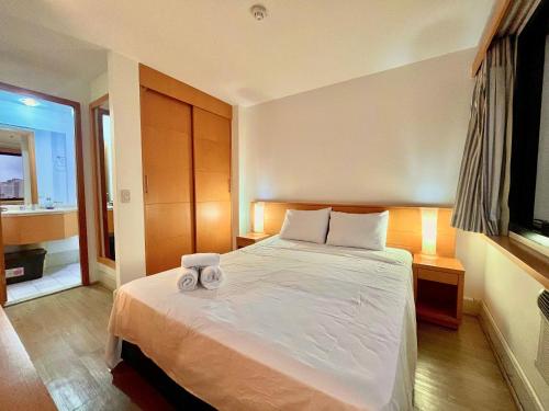 a bedroom with a bed with two towels on it at LFlats Hotel Alameda Lorena Jardins in Sao Paulo
