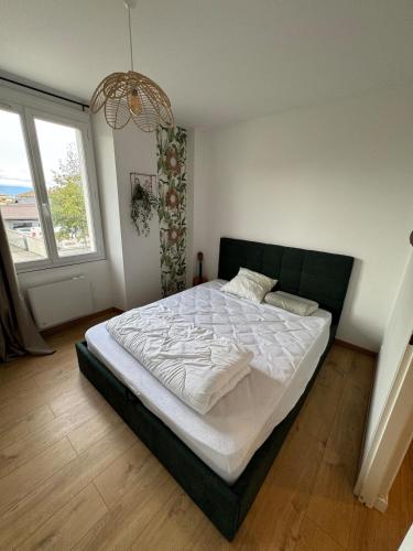 une chambre avec un grand lit avec des draps blancs dans l'établissement La Terrasse Ouest, à Thonon-les-Bains