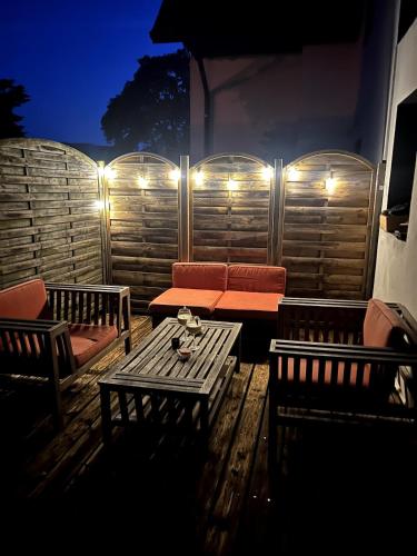 d'une terrasse avec un canapé, une table et des lumières. dans l'établissement La Terrasse Ouest, à Thonon-les-Bains