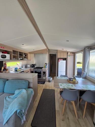 a kitchen and living room with a table and chairs at Barbara's Caravan Craig Tara in Ayr