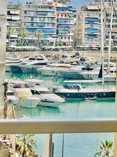 a group of boats docked in a harbor with buildings at Piraeus Pasalimani LargeTerrace Seaview Apartment in Piraeus