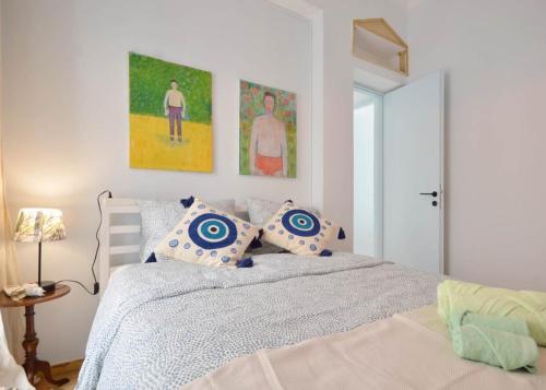 a bedroom with a bed with blue and white pillows at Piraeus Pasalimani LargeTerrace Seaview Apartment in Piraeus