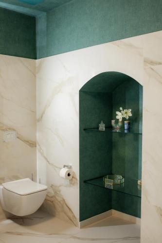 a bathroom with a toilet and a green wall at Ferienwohnung am Dom mit Parkplatz in Zwickau
