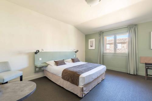 a bedroom with a large bed and a chair at Mercure Aix-En-Provence Sainte-Victoire in Châteauneuf-le-Rouge