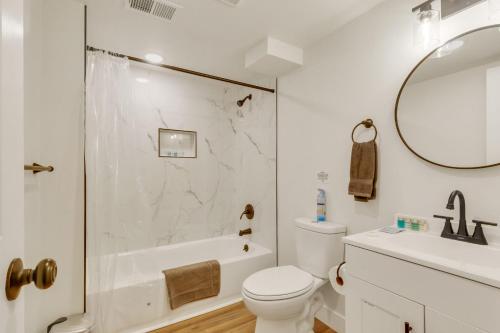 a white bathroom with a toilet and a sink at Vacation Launch Pad - Great for Groups in Arvada