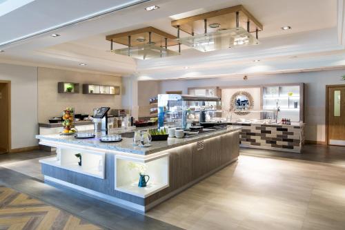 a restaurant with a counter in the middle of a room at Mercure Newcastle George Washington Hotel Golf & Spa in Newcastle upon Tyne