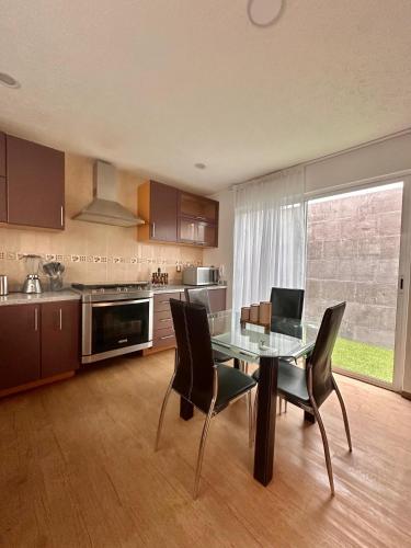 a kitchen with a glass table and black chairs at Cozy house in central location in Hércules