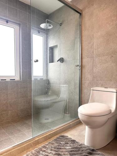 a bathroom with a glass shower and a toilet at Cozy house in central location in Hércules