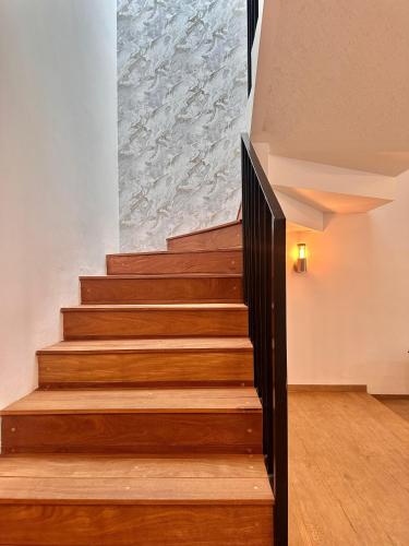 a stairwell with wooden steps and a stone wall at Cozy house in central location in Hércules