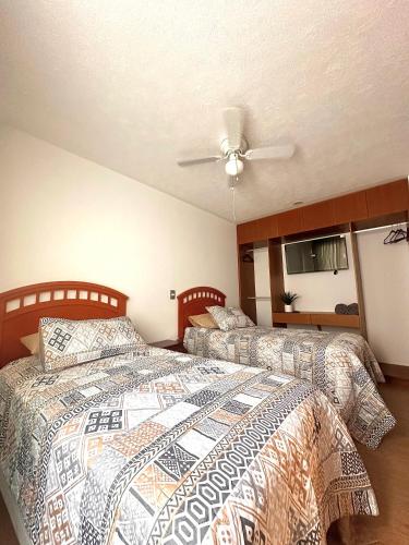 a bedroom with two beds and a ceiling fan at Cozy house in central location in Hércules
