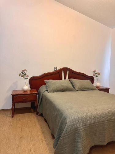 a bedroom with a bed and two vases on a table at Cozy house in central location in Hércules