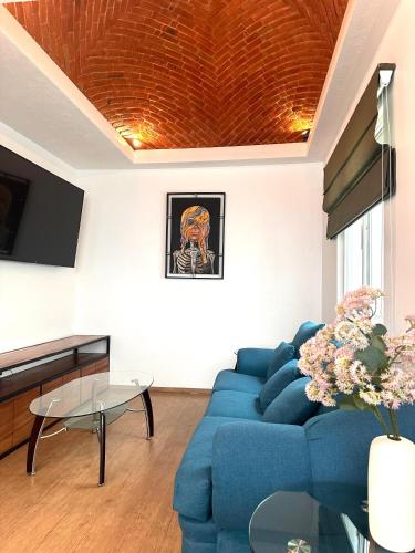 a living room with a blue couch and a table at Cozy house in central location in Hércules
