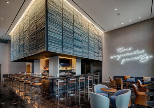 a bar in a restaurant with chairs and tables at The Joseph, a Luxury Collection Hotel, Nashville in Nashville
