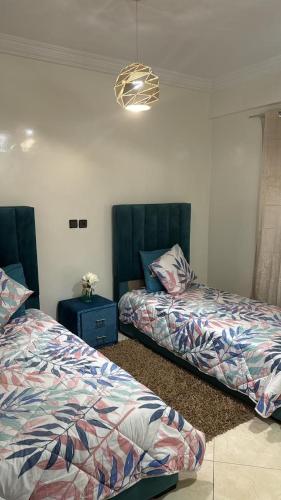 a bedroom with two beds and a blue table at Appartement BM - Béni Mellal in Beni Mellal
