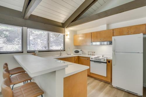 a kitchen with a white refrigerator and wooden cabinets at 3 Mi to Lake Arrowhead Cabin with Furnished Deck! in Twin Peaks