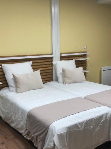 Cette chambre comprend 2 lits avec des draps et des oreillers blancs. dans l'établissement Les Halles, à Chaumont