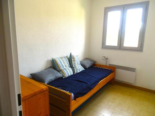 une chambre avec un lit avec des draps bleus et une fenêtre dans l'établissement Dog Family House, à Cavalaire-sur-Mer