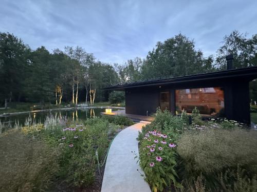 a house with a garden next to a lake at Silma Retreat Hunting Castle in Herjava