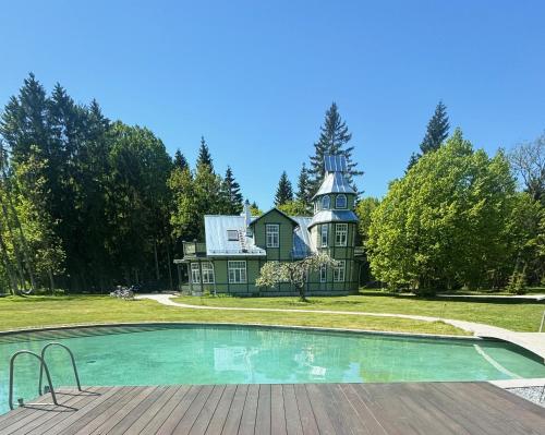 a house with a pool in front of it at Silma Retreat Hunting Castle in Herjava