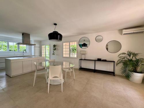a kitchen with a table and chairs and mirrors at La Villa verdoyante in Baillargues