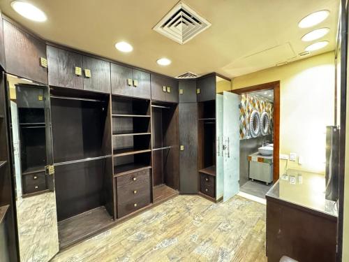une grande pièce avec des armoires en bois et un dressing dans l'établissement فيلا داخل كمبواند ويستاون بيفرلي هيلز الشيخ زايد رقم هاتف صفر صفر اتنين صفر واحد واحد صفر اتنين اربعه ثلاثه صفر 222, à Sheikh Zayed