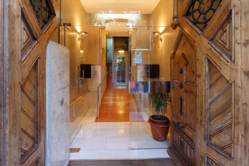 a hallway with wooden doors and a potted plant at CIUDAD CONDAL Hostal - Paseo de Gracia in Barcelona