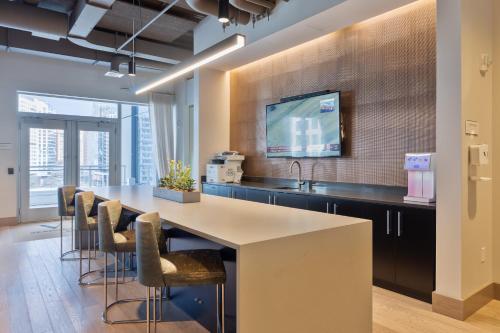 a kitchen with a large island with bar chairs at Luxury Apt Downtown Seaport in Boston