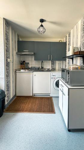 une grande cuisine avec des placards blancs et un lave-vaisselle dans l'établissement Studio au cœur de Lannion, à Lannion