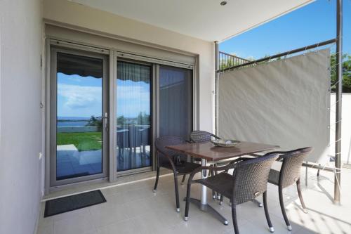 a dining room with a table and chairs on a balcony at Panorama Dream Studios B in Vourvourou