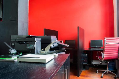 an office with a red wall and a printer on a counter at Onomo Hotel Dar es Salaam in Dar es Salaam