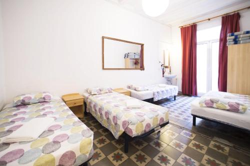 a hotel room with two beds and a couch at Pensión Arosa in Barcelona