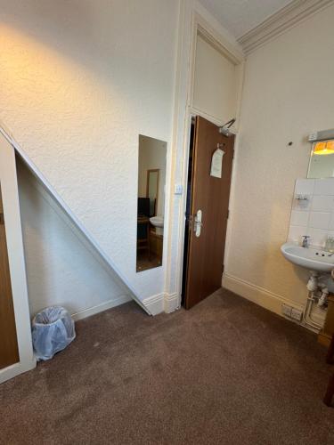 a bathroom with a sink and a stairway with a mirror at Near Hylands hotel in Nottingham