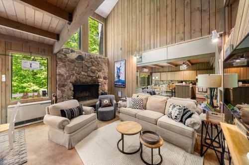 sala de estar con sofá y chimenea de piedra en North Conway townhouse Near White Mountains, en Conway
